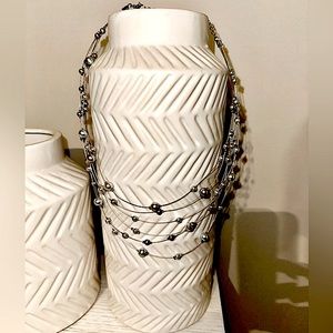 Faux "floating cascading pearls" necklace in gray/silver tones.